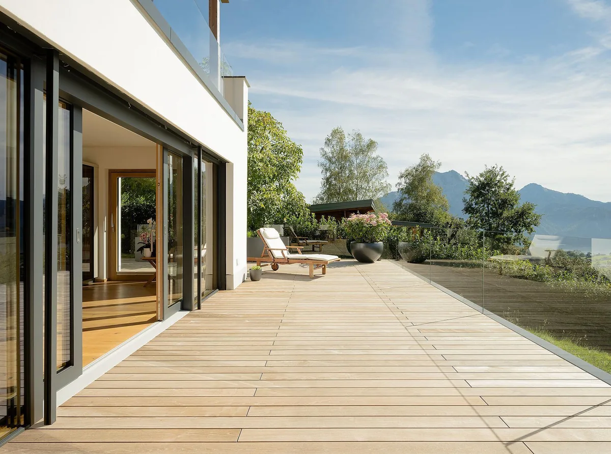 Weitläufige Holzterrasse mit geöffneten ACTUAL Schiebeelementen