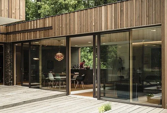 Großzügige ACTUAL Schiebeelemente zwischen Wohnraum und Holzterrasse